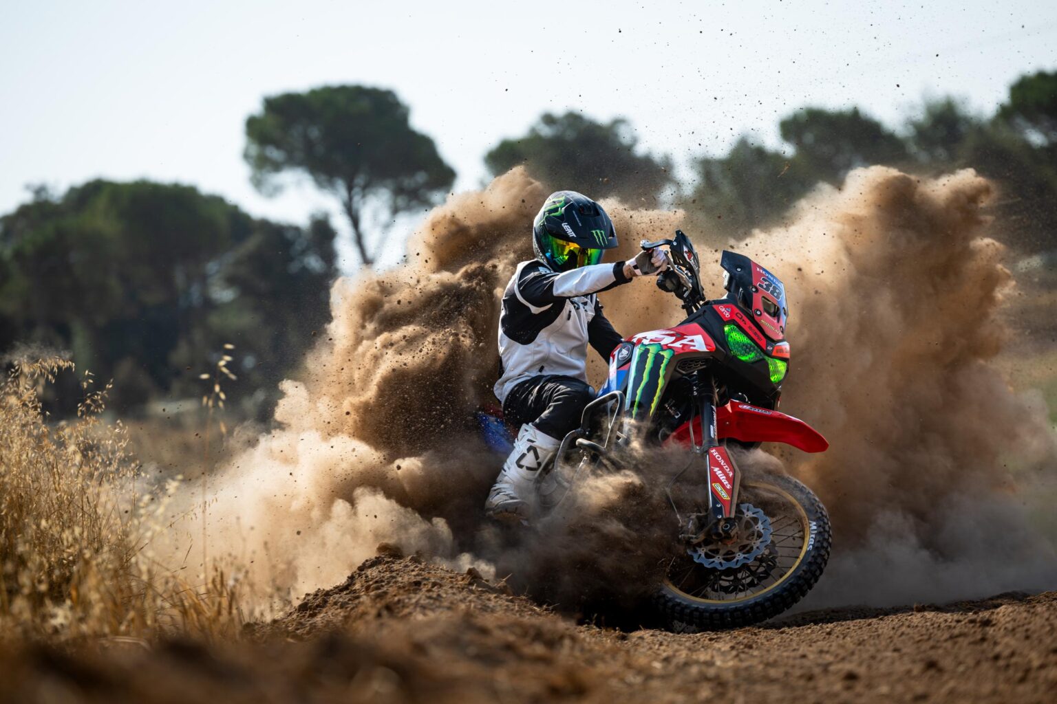 Reiseenduro wirbelt in einer Motocross-Kurve Erde auf